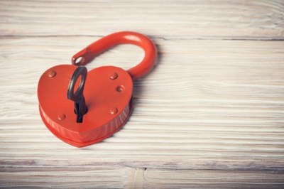 36508847 - open heart shaped lock and key over light vintage wooden background